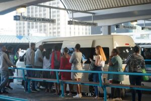 Passengers queueing next to a minibus taxi at the Cape Town taxi rank.