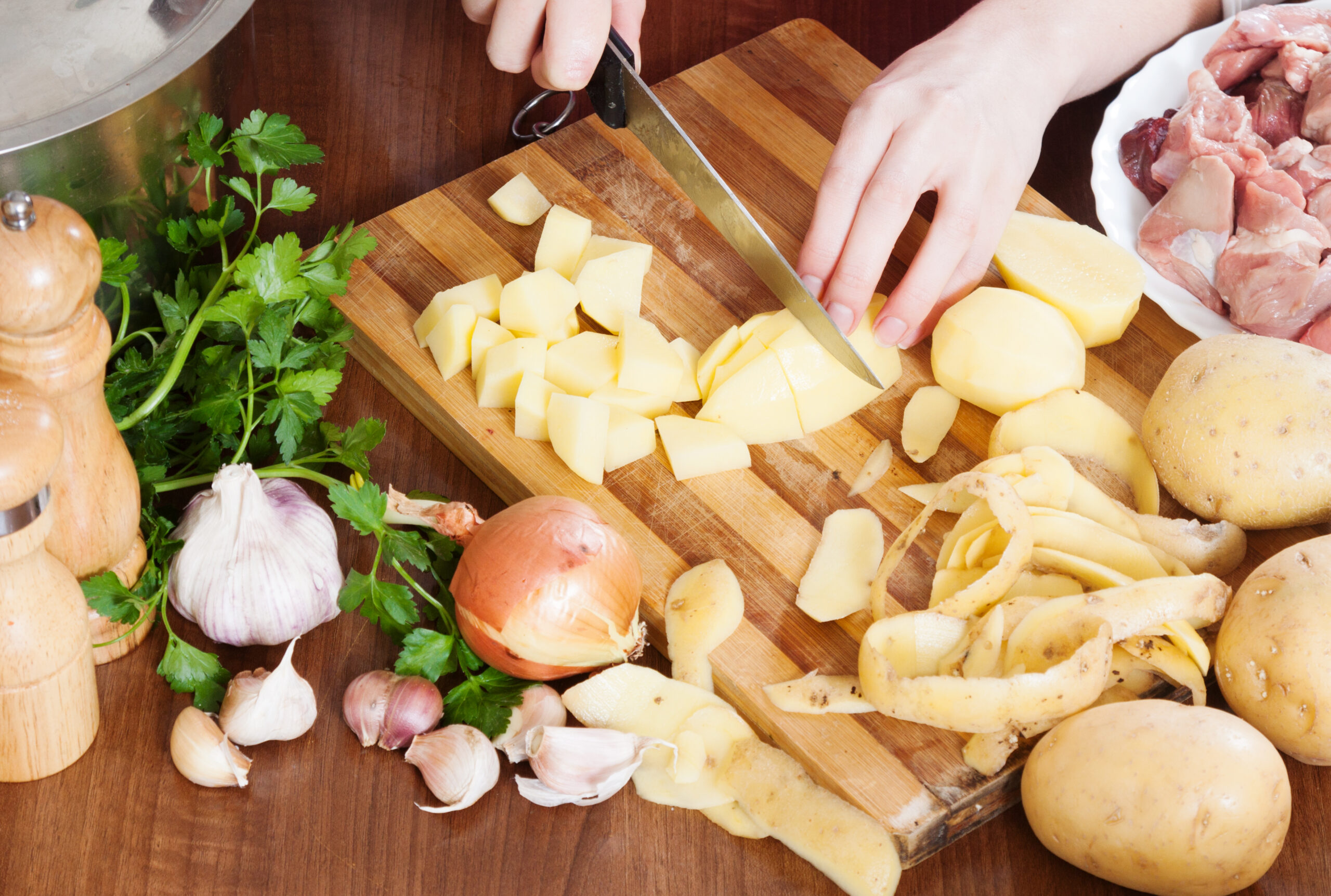 A woman chopping potatoes to use as ingredient in breyani.